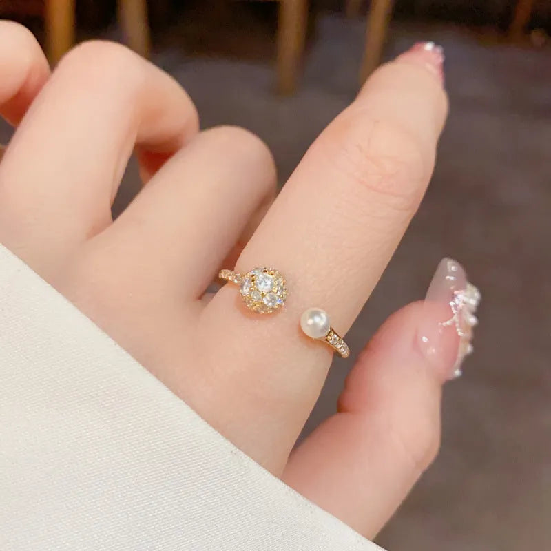 Gold plated open-end ring with round zircon pearl element on copper base