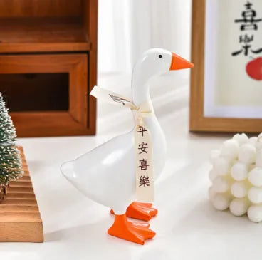 White simulation duck resin magnetic ornament on metal surface holding a note