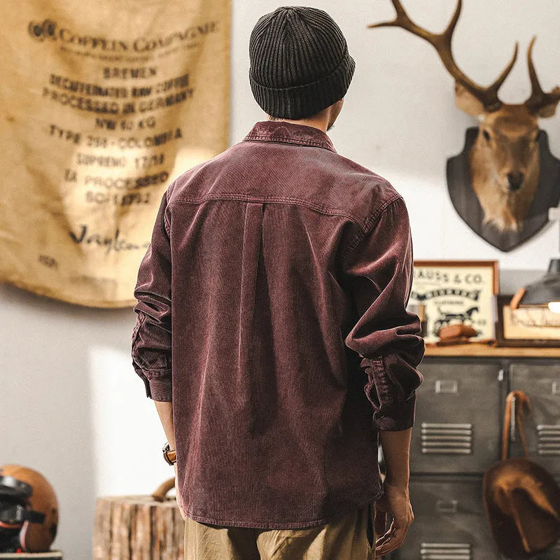 Man wearing a red loose-fit corduroy shirt jacket with long sleeves.