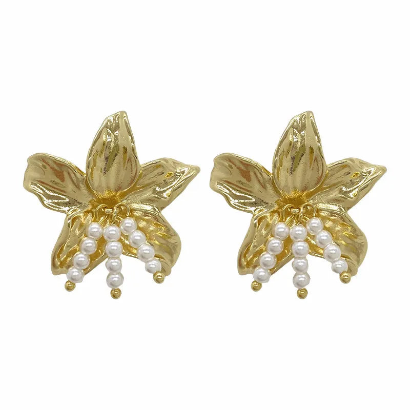 Gold H1795 metal flower earrings with a pearl centre, showing exaggerated floral shape and niche style.
