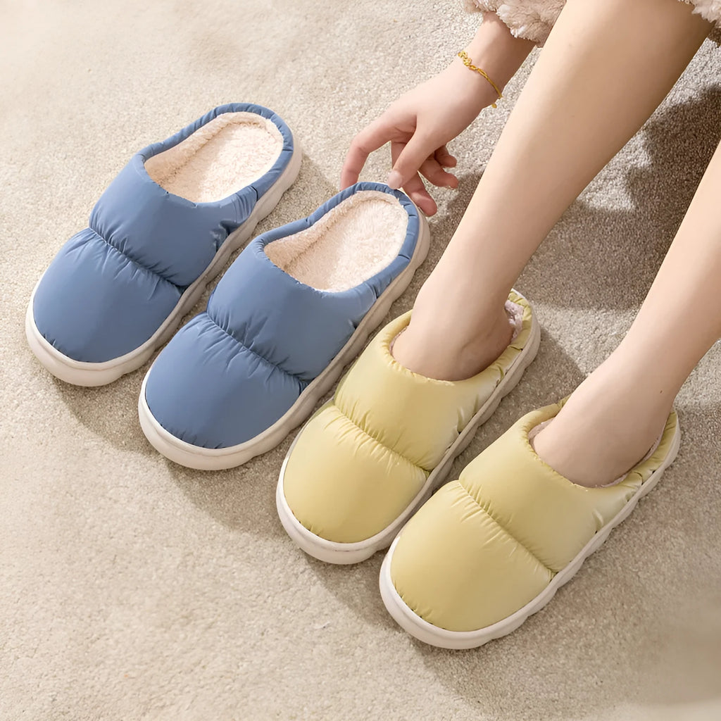 Pair of thick-soled winter slippers with artificial leather upper and plush lining, shown in a choice of colours.