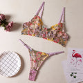 Floral patterned mesh bra with steel ring T-back in various colours on a mannequin.