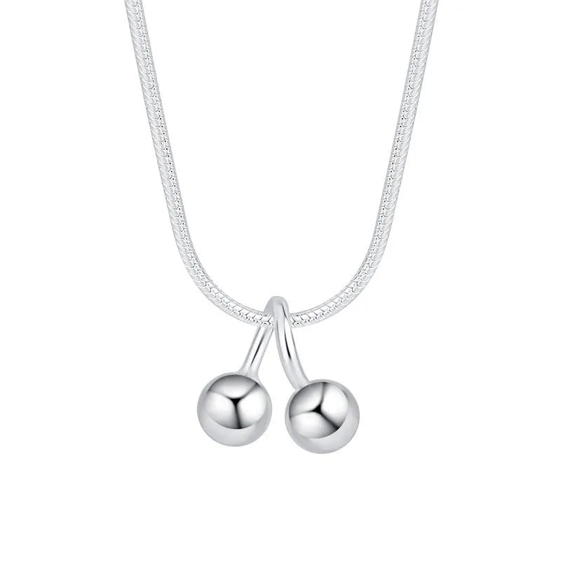 Silver necklace with cherry pendant on an adjustable snake bone chain.