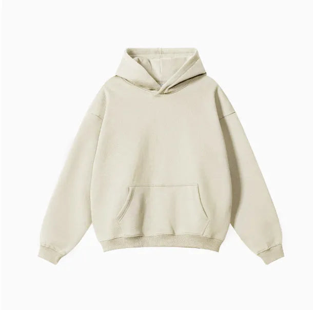 Man wearing a loose-fit grey cotton terry hooded sweater with drop-shoulder sleeves.