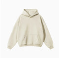 Man wearing a loose-fit grey cotton terry hooded sweater with drop-shoulder sleeves.