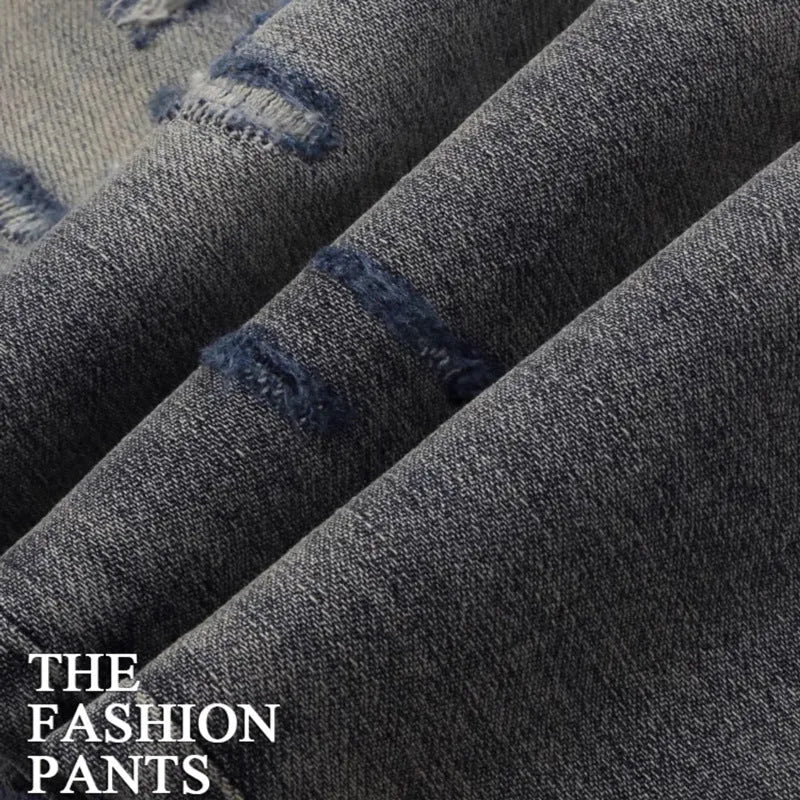 Men's slim fit jeans with a washed-out faded finish and embroidered patch details on the leg.