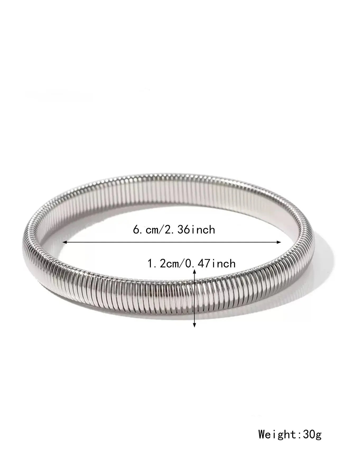 Close-up of a women's titanium steel bracelet with a vertical stripe ring pattern, shown in a gold tone finish on a wrist.