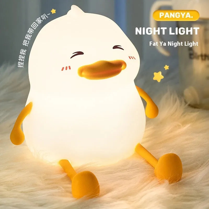 Chubby rechargeable silicone pat night lamp on desk holding a mobile phone