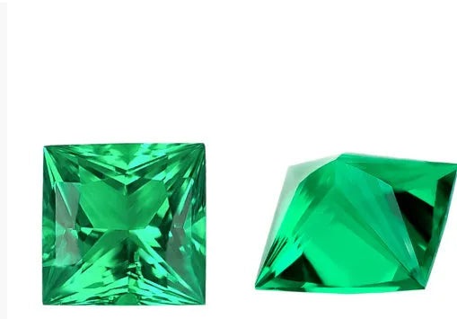 Cultivated emerald gemstone in Columbian green colour showing various polished cuts on a white background.