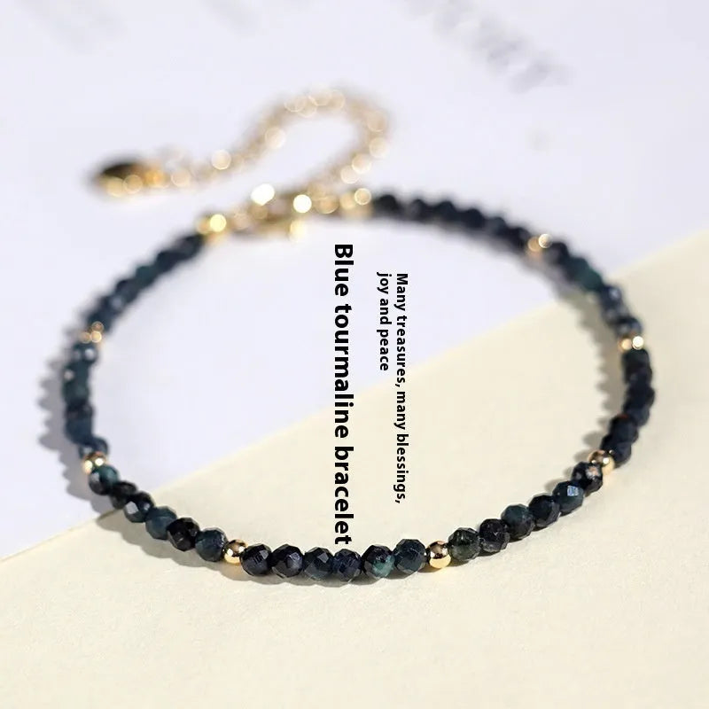Close-up of a women's blue tourmaline beaded bracelet with 3mm beads and spacer sections.