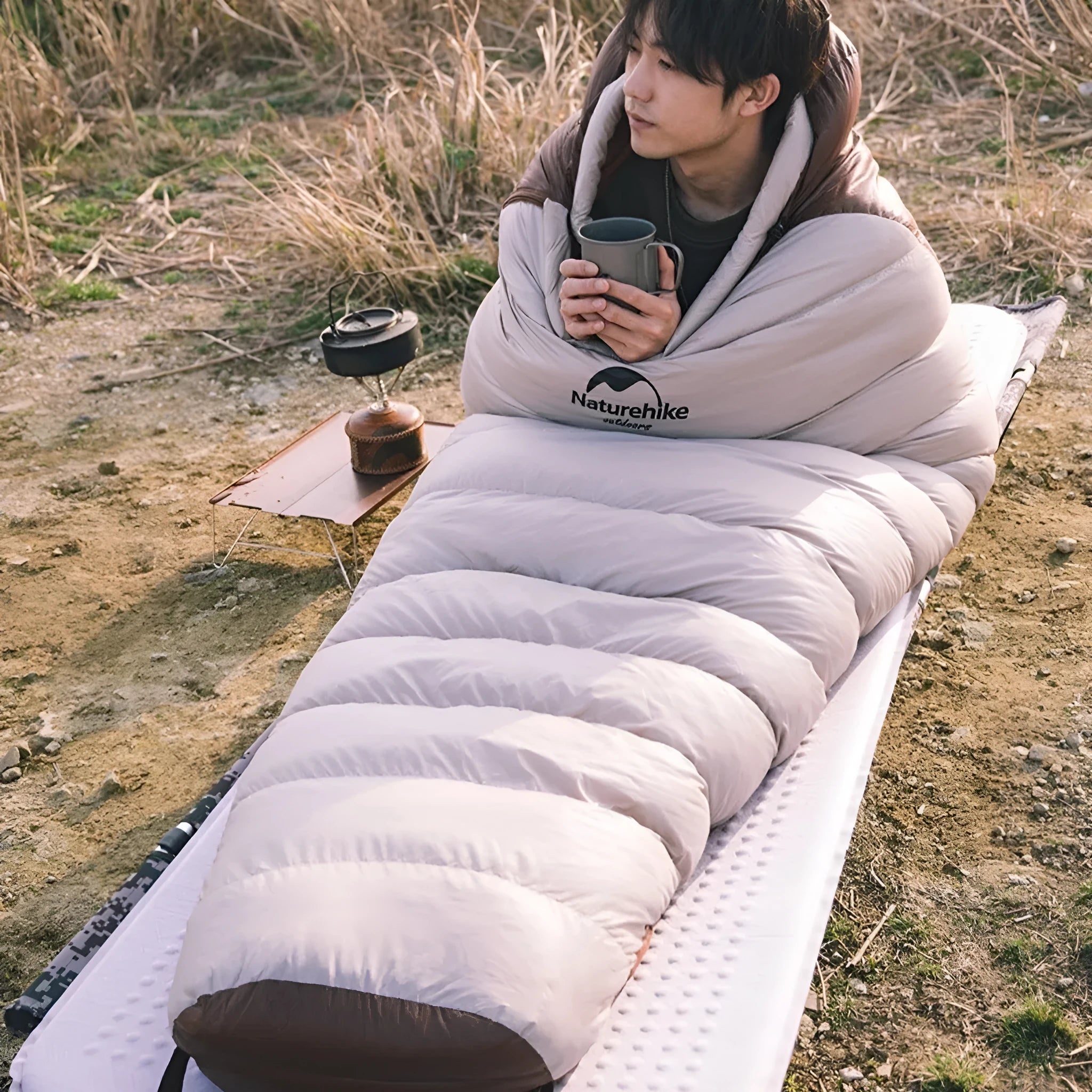 Goose down mummy sleeping bag with storage bag, shown in a neutral colour for adult outdoor use