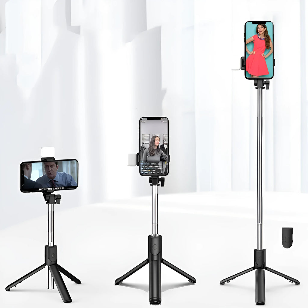 Black Bluetooth selfie stick with extended tripod legs, fill light, and a phone mounted in the 360-degree rotatable holder.