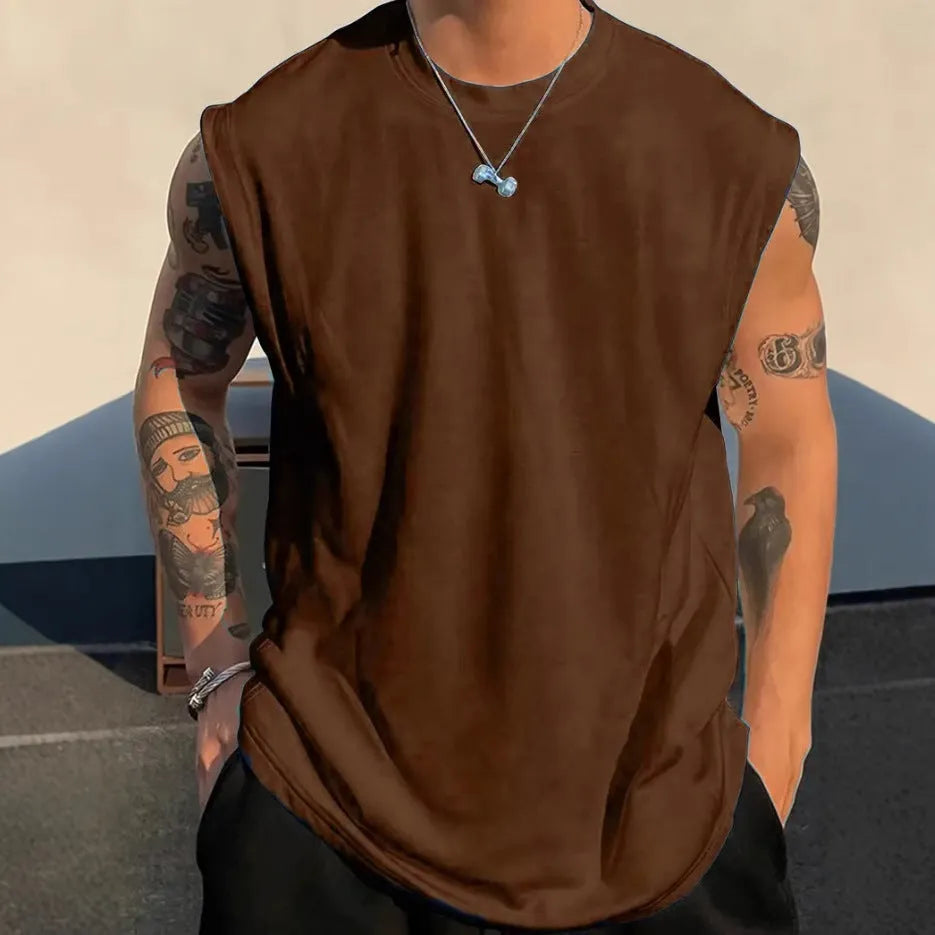 Man wearing a loose, solid-colour cotton sleeveless tank top in a casual setting.