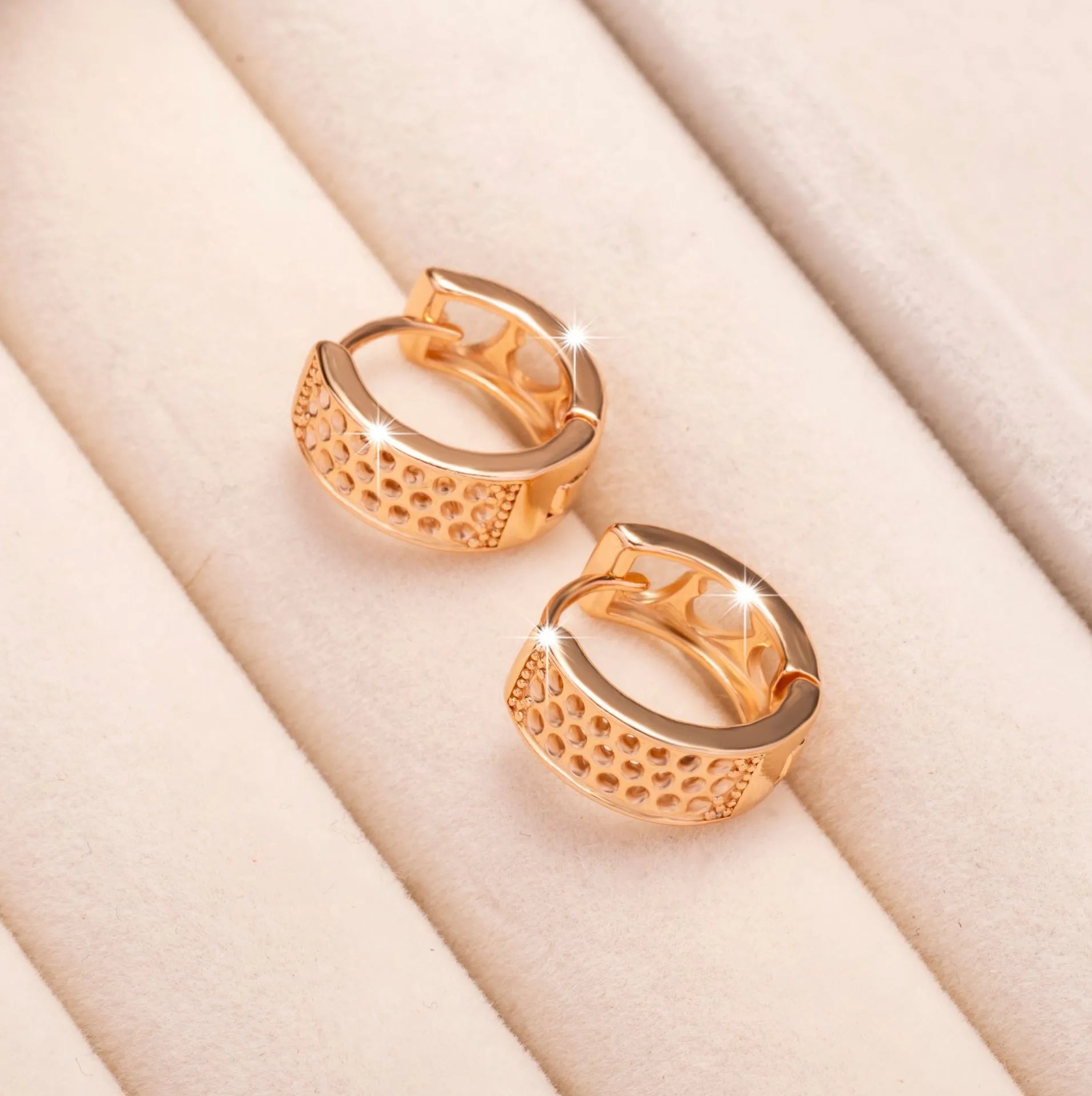 Circular rose gold earrings with three cut-out heart shapes