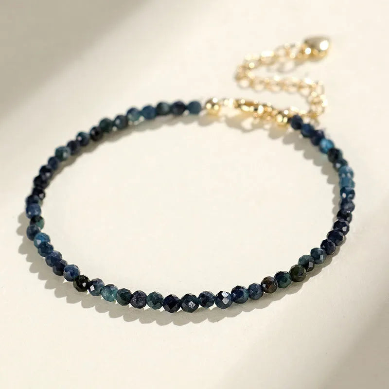 Close-up of a women's blue tourmaline beaded bracelet with 3mm beads and spacer sections.