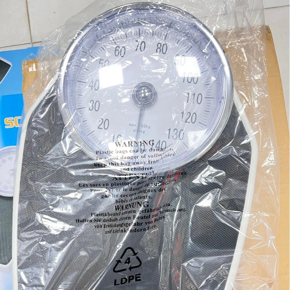 Black mechanical body weight scale with large dial and pointer on a simple platform.