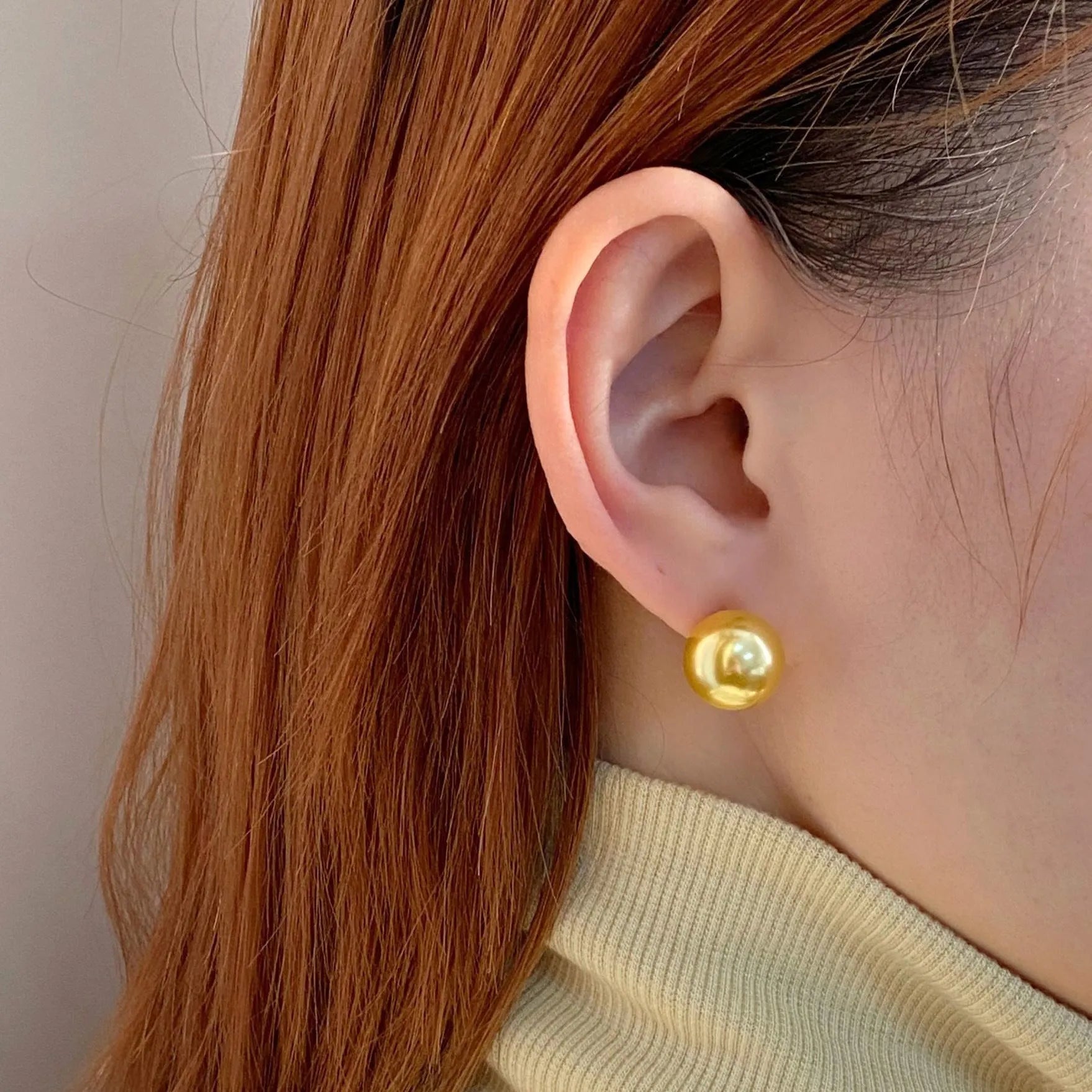 A pair of large silver pearl stud earrings with an eight-pointed star geometric design on a white background.