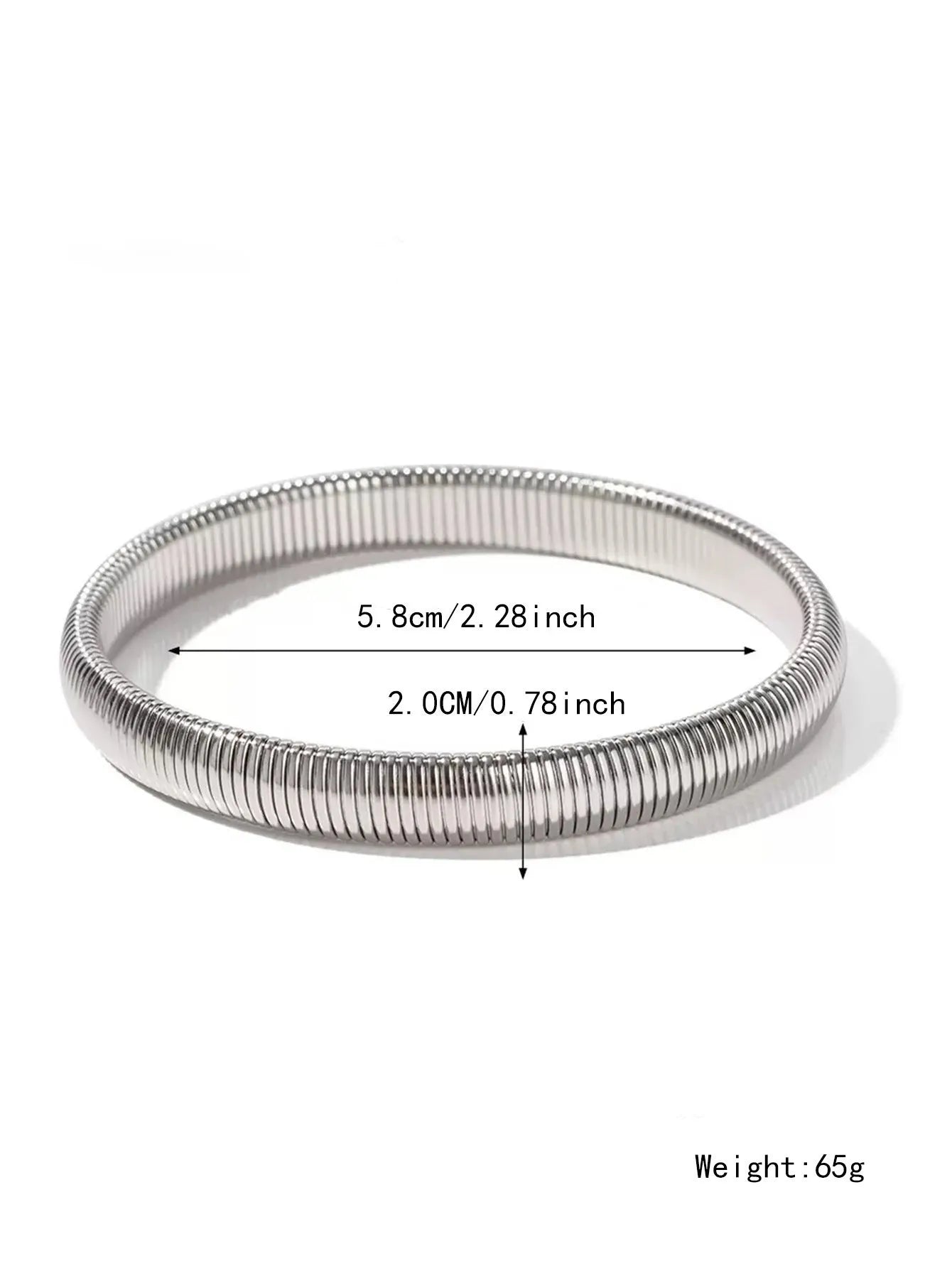 Close-up of a women's titanium steel bracelet with a vertical stripe ring pattern, shown in a gold tone finish on a wrist.