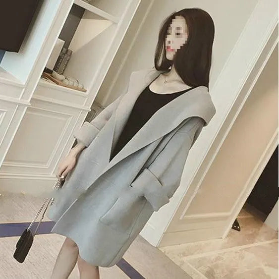 Plus size woman modelling a loose grey cotton coat with lace detailing and long sleeves.
