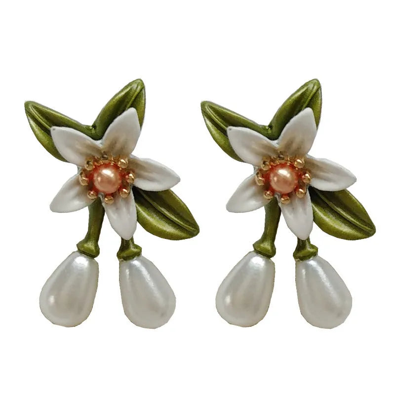 Two pairs of women's floral alloy earrings: one clip-on flower style and one pair of sterling silver needle flower studs.