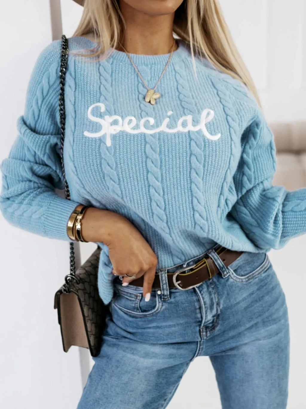 Blue crew neck pullover sweater with embroidered text letters on the front.