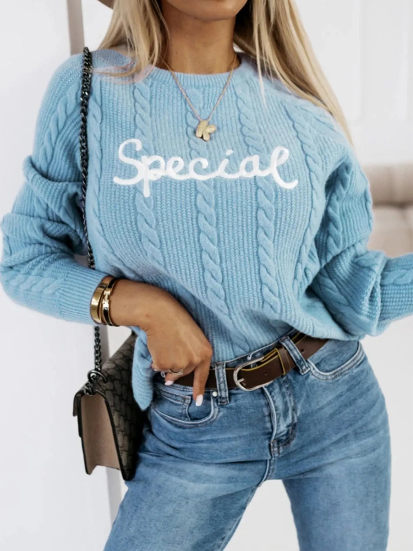 Blue crew neck pullover sweater with embroidered text letters on the front.