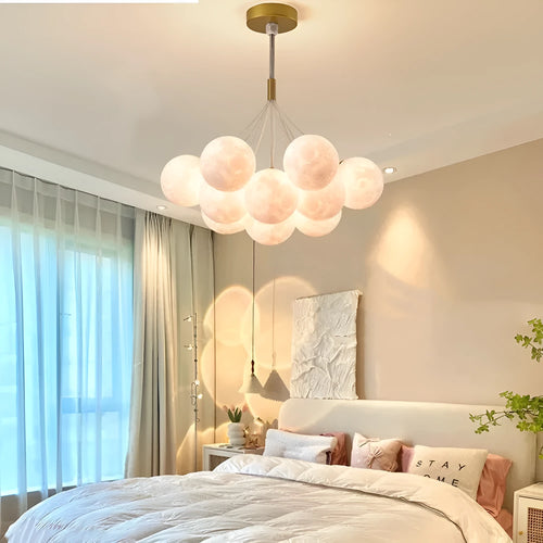 Nordic fish-shaped pendant chandelier with cluster of spherical moon bubble lights in gold or black finish.
