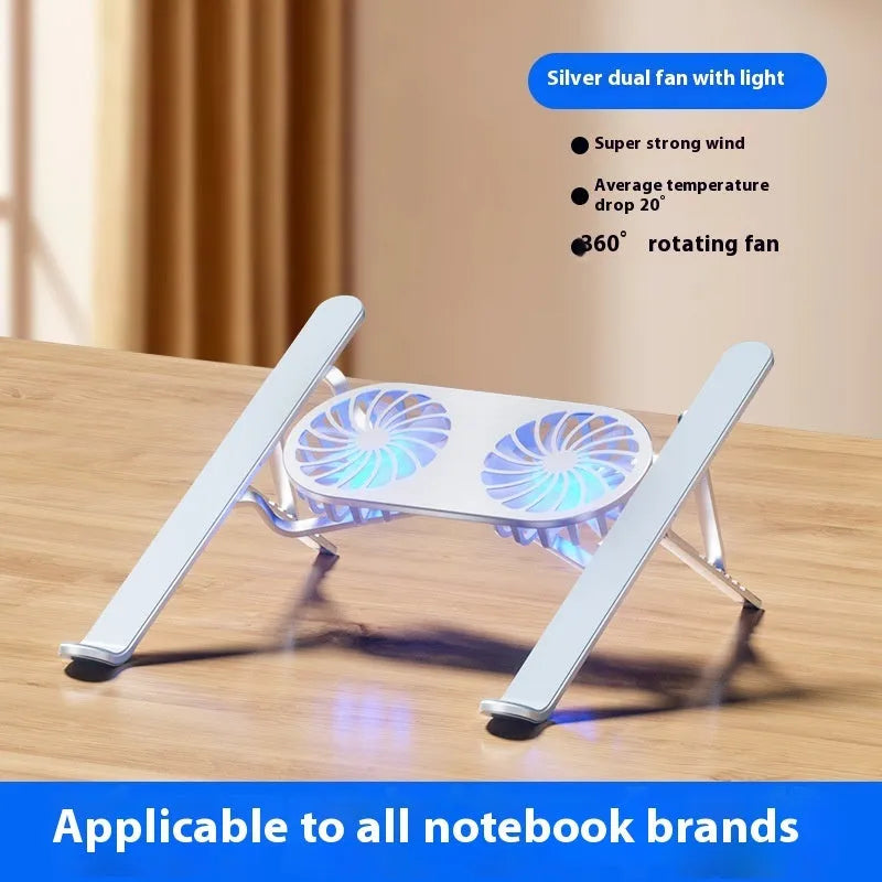 Silver aluminium laptop stand with twin fans raised at an angle on a wooden desk.