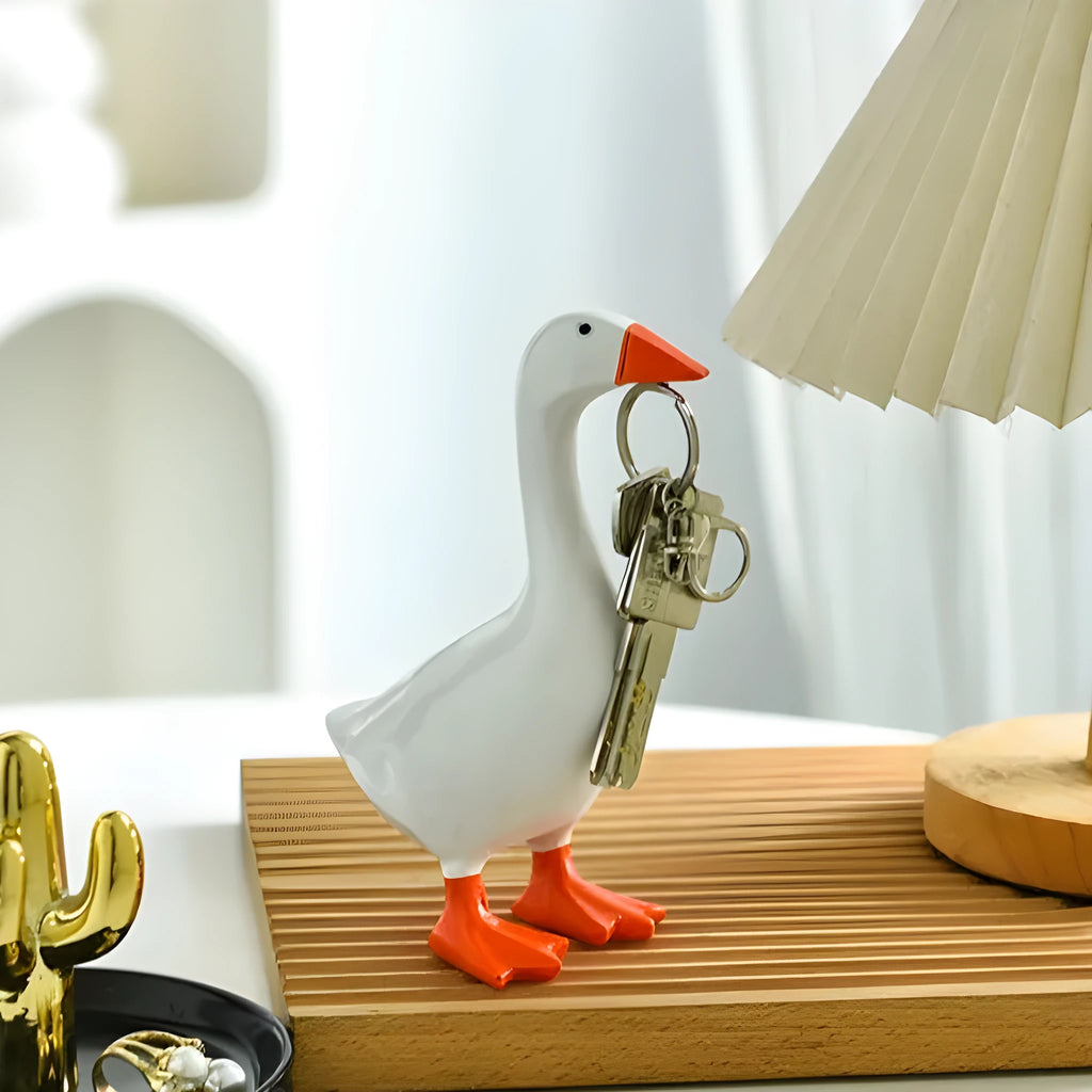 White simulation duck resin magnetic ornament on metal surface holding a note