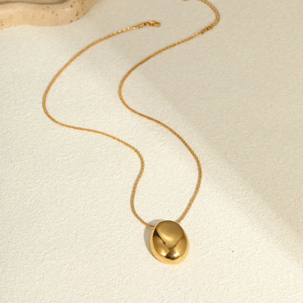Gold-plated geometric pendant necklace with stainless steel chain on black background