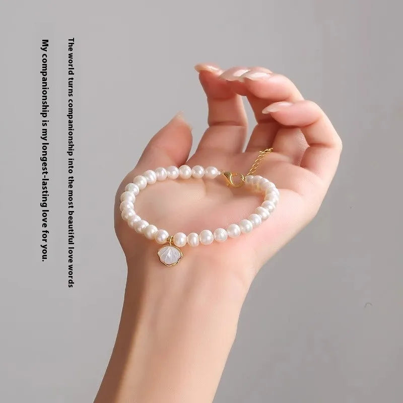 Women's freshwater pearl bracelet with fan design on a 16cm band, showing elastic string and extension chain options.