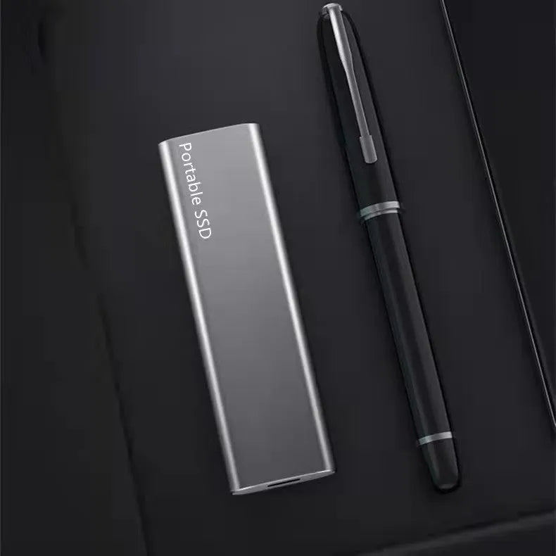 Red ultra-thin metal external SSD hard drive with high storage capacity on a desk.