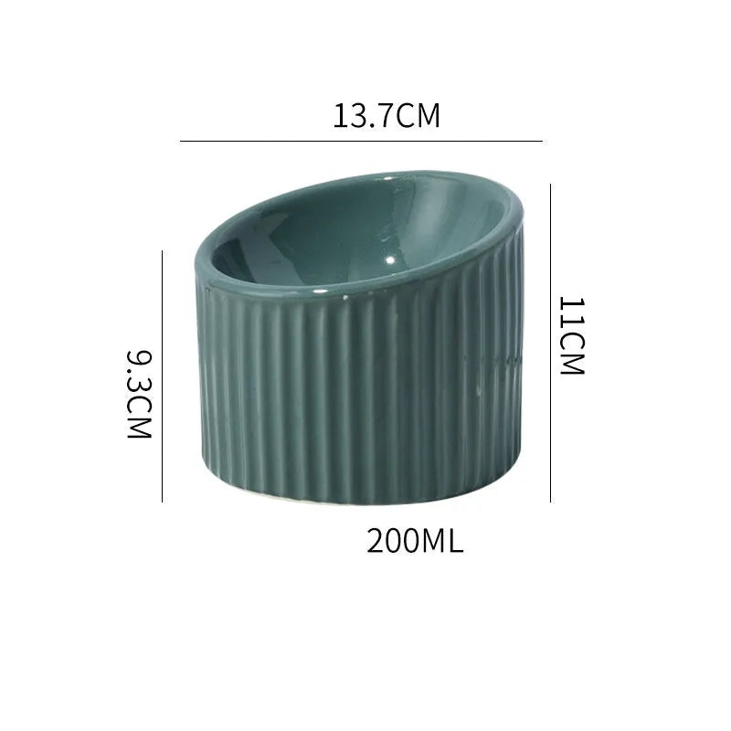 Ceramic elevated cat bowl in green, showing tilted round dish on a raised stand.