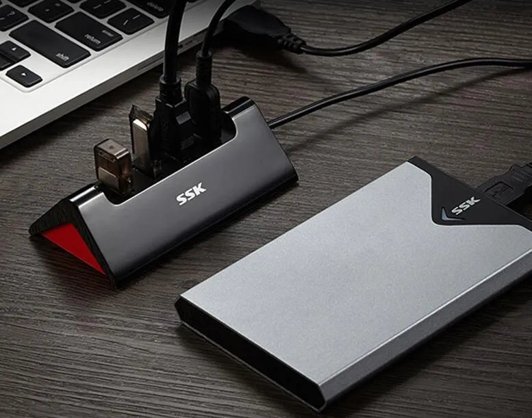 Black USB expansion hub with four ports showing USB 3.0 and USB 2.0 interfaces on ABS plastic casing
