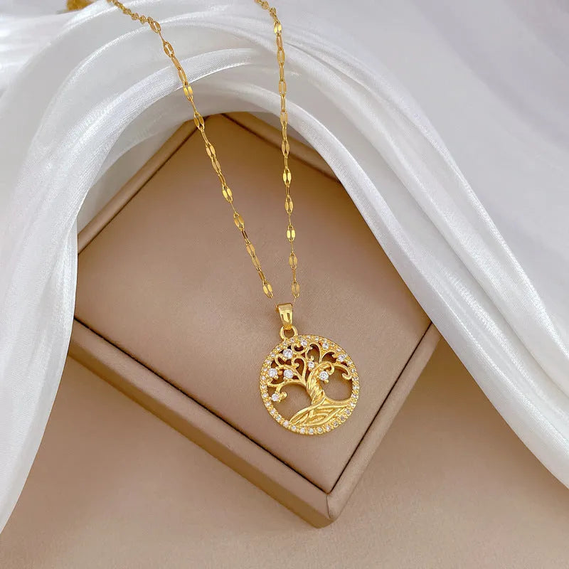 Gold-plated cross necklace with mother-of-pearl lucky tree pendant and rhinestone detailing on adjustable lip chain