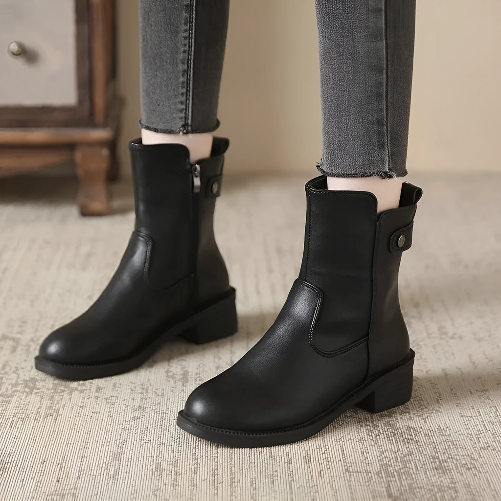Black women's short ankle boots with a side zip, low heel, and round toe on a rubber sole.