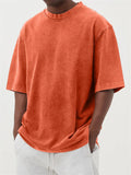 Man wearing a loose-fit, stone-washed distressed pullover T-shirt in a solid colour.