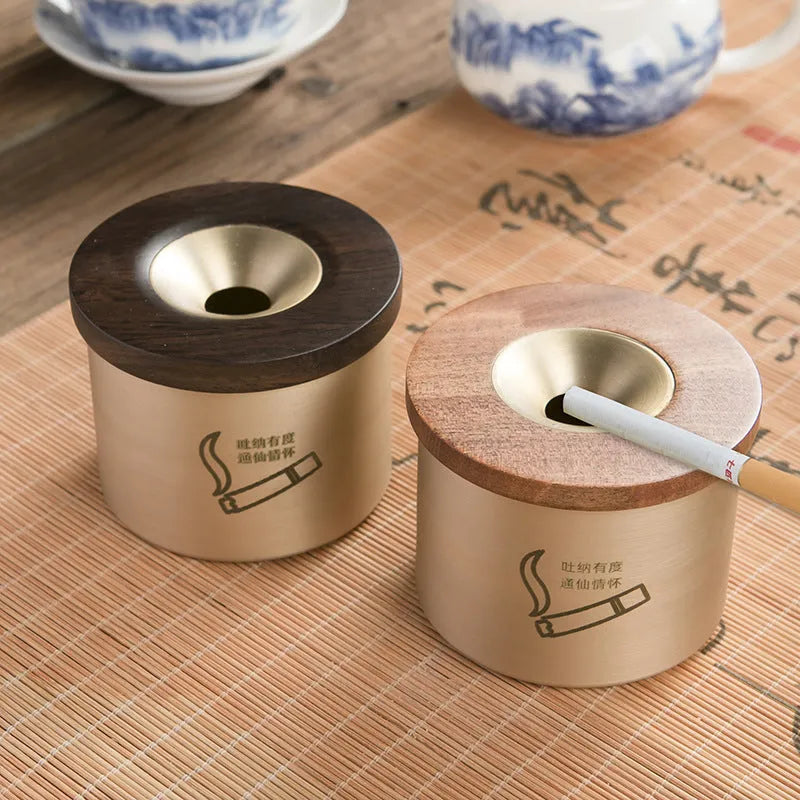 Brass ashtray with wooden lid showing central hole design for ash collection
