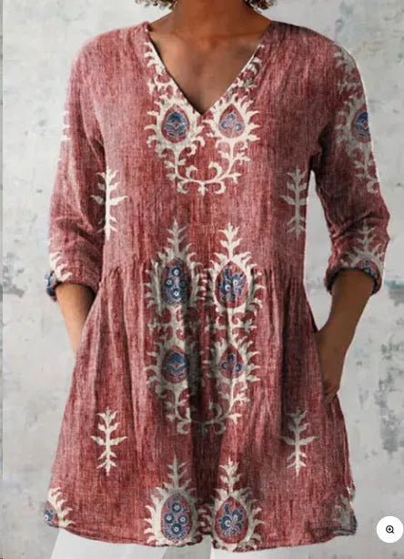 A woman modelling a printed, loose-fitting dress with a wide waist and three-quarter length sleeves.