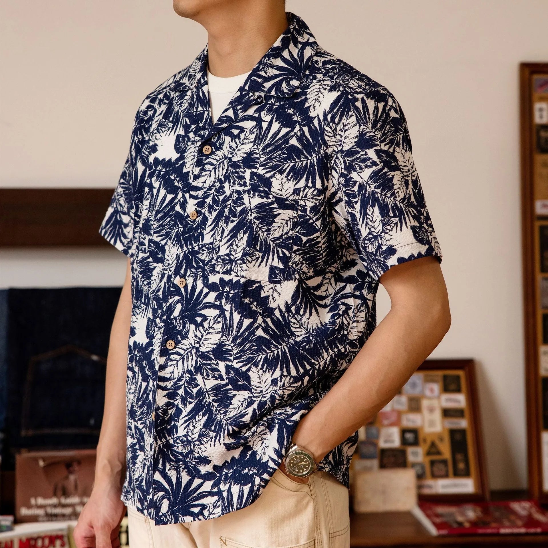 Men's green seersucker shirt with floral print and a Cuban collar, laid flat.