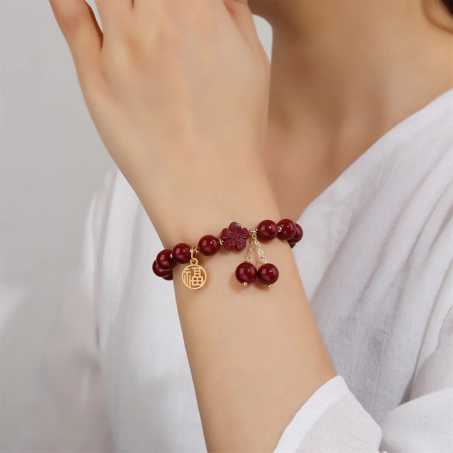 Women's cinnabar bracelet with fu character charm in purple gold sand colour and peach blossom detailing