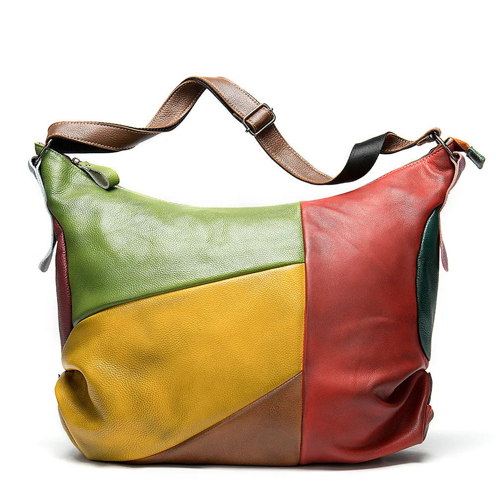 Brown cowhide leather travel bag with stitching detail, shown with a laptop and worn crossbody.