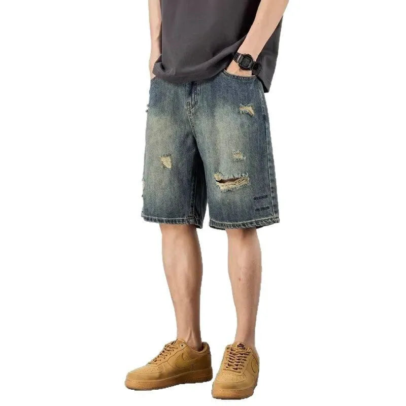 Men's blue denim shorts with loose hole distressing and straight leg silhouette