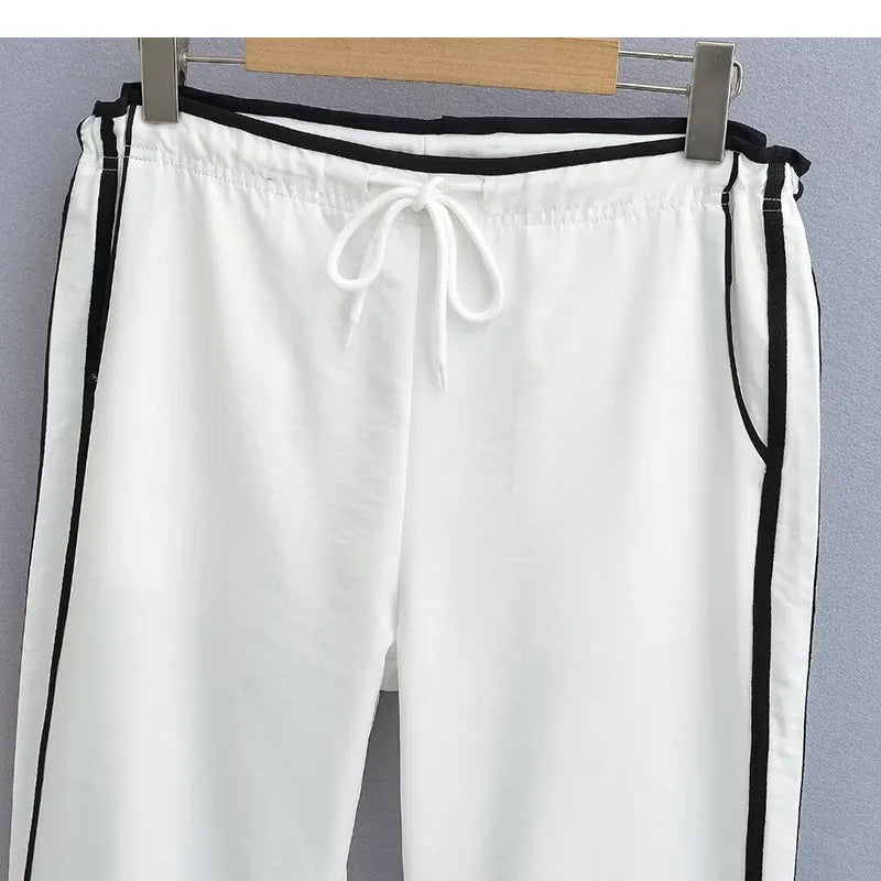Women's navy blue loose straight-leg trousers with thin fabric and ribbon parallel bars contrast detail.