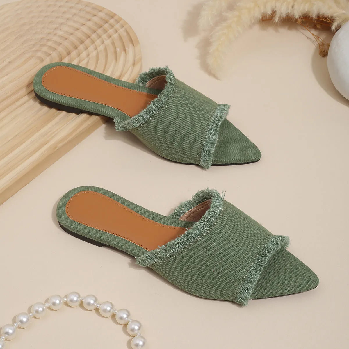 Women's casual denim flat slippers with leather lining and tassel detail.