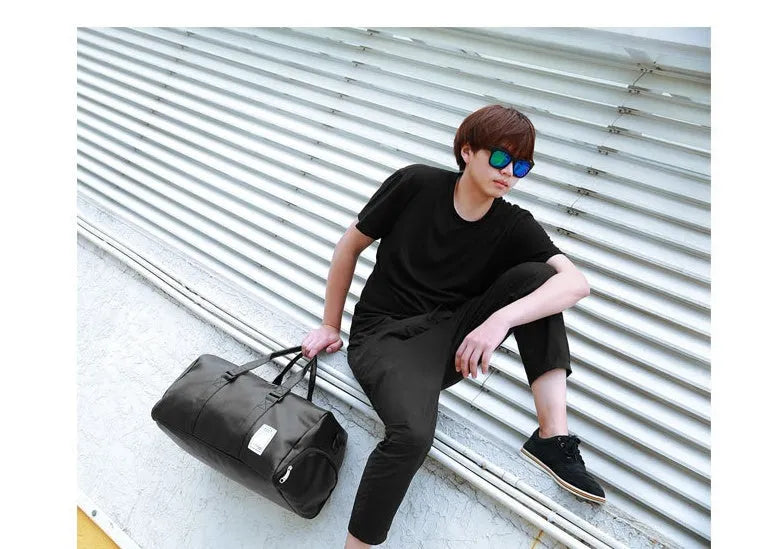 Black waterproof sports bag with diagonal straps and separate side shoe compartments.