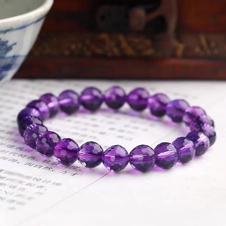 Handcrafted 128-facet crystal ametrine bracelet with detailed beads on a wrist.