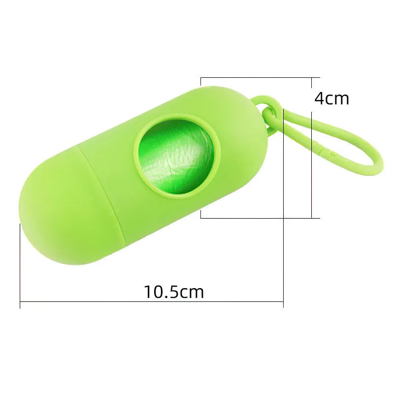 Compact black dog waste bag dispenser with a metal hook and Velcro strap, shown attached to a dog lead.