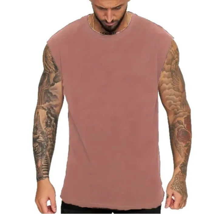 Man wearing a loose, solid-colour cotton sleeveless tank top in a casual setting.