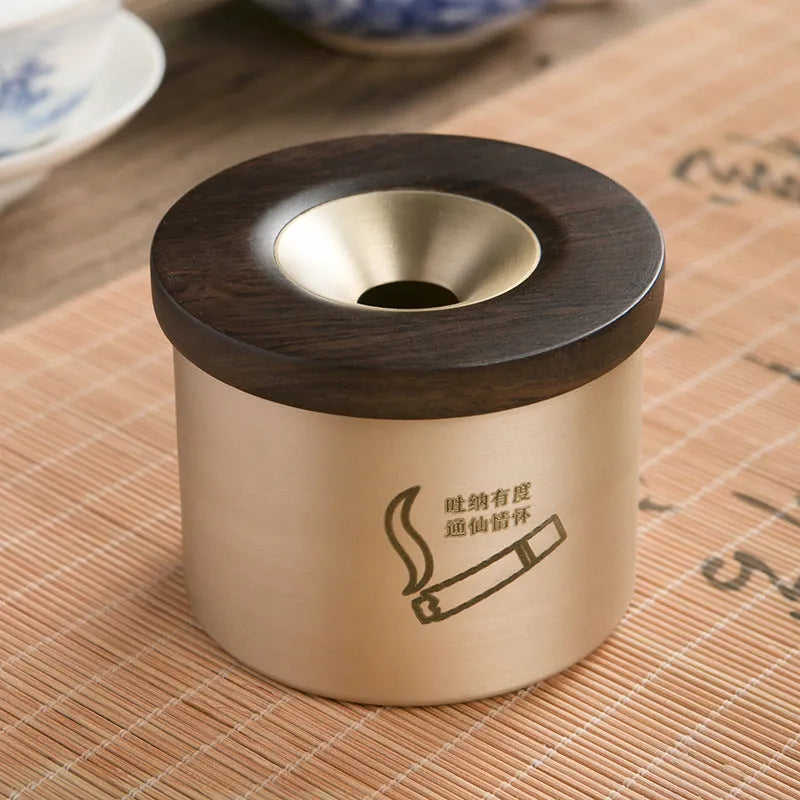 Brass ashtray with wooden lid showing central hole design for ash collection